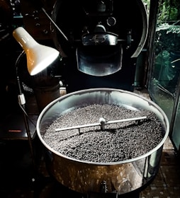 A modern roasting facility with shiny equipment and bags of freshly roasted coffee beans.