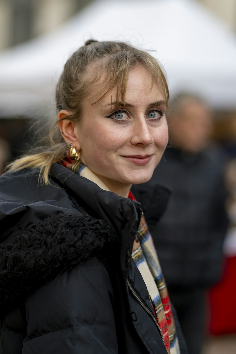 a woman wearing a black jacket and a scarf