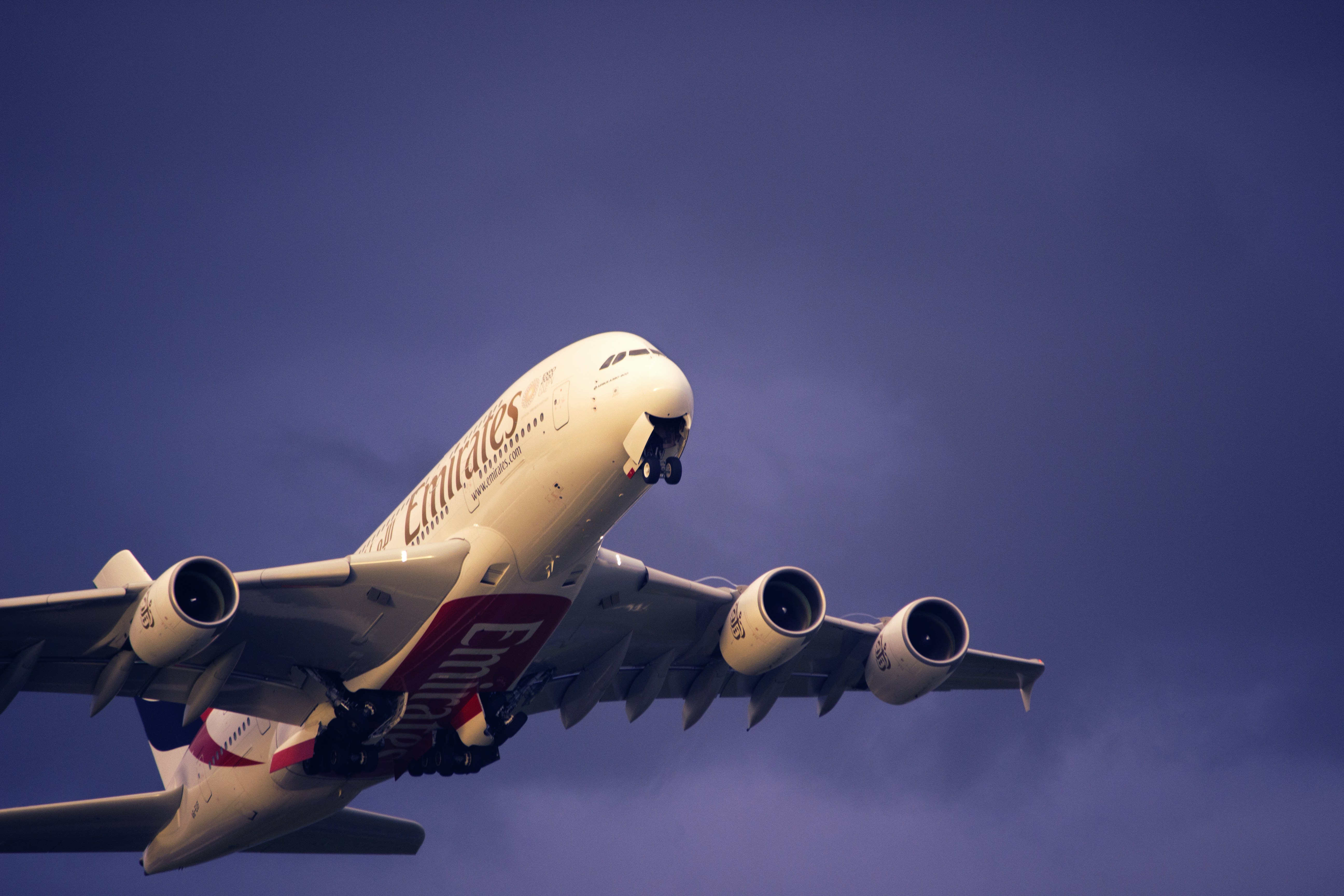 a large jetliner flying through a cloudy blue sky, 