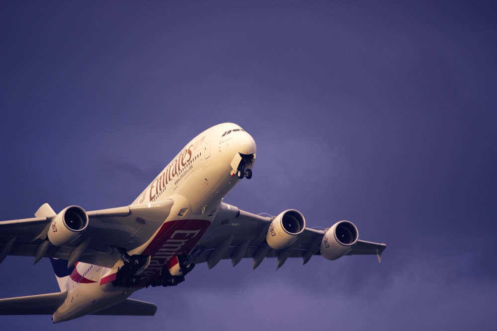 a large jetliner flying through a cloudy blue sky