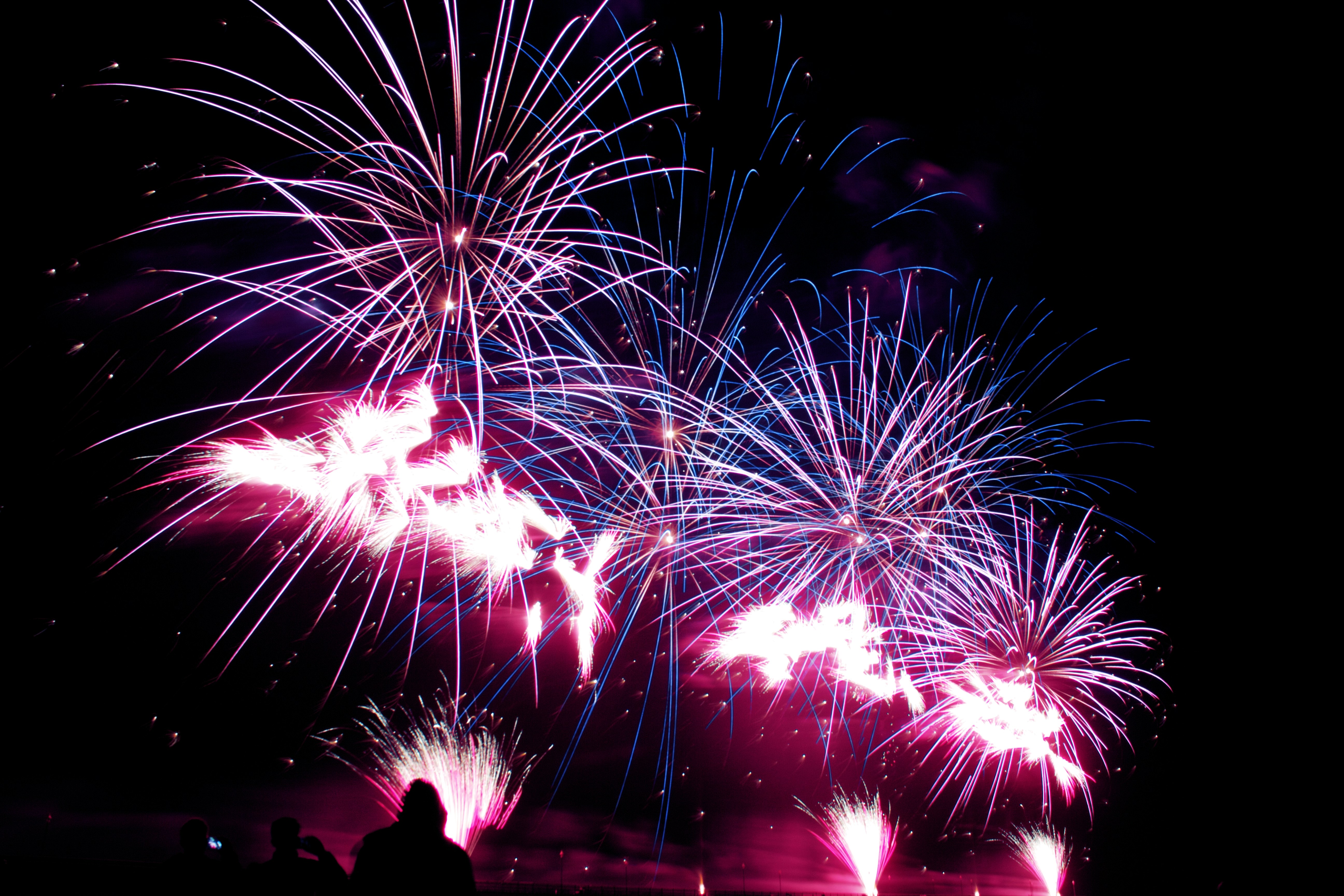a group of people watching fireworks in the night sky