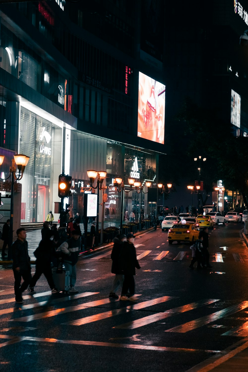 um grupo de pessoas atravessando uma rua à noite