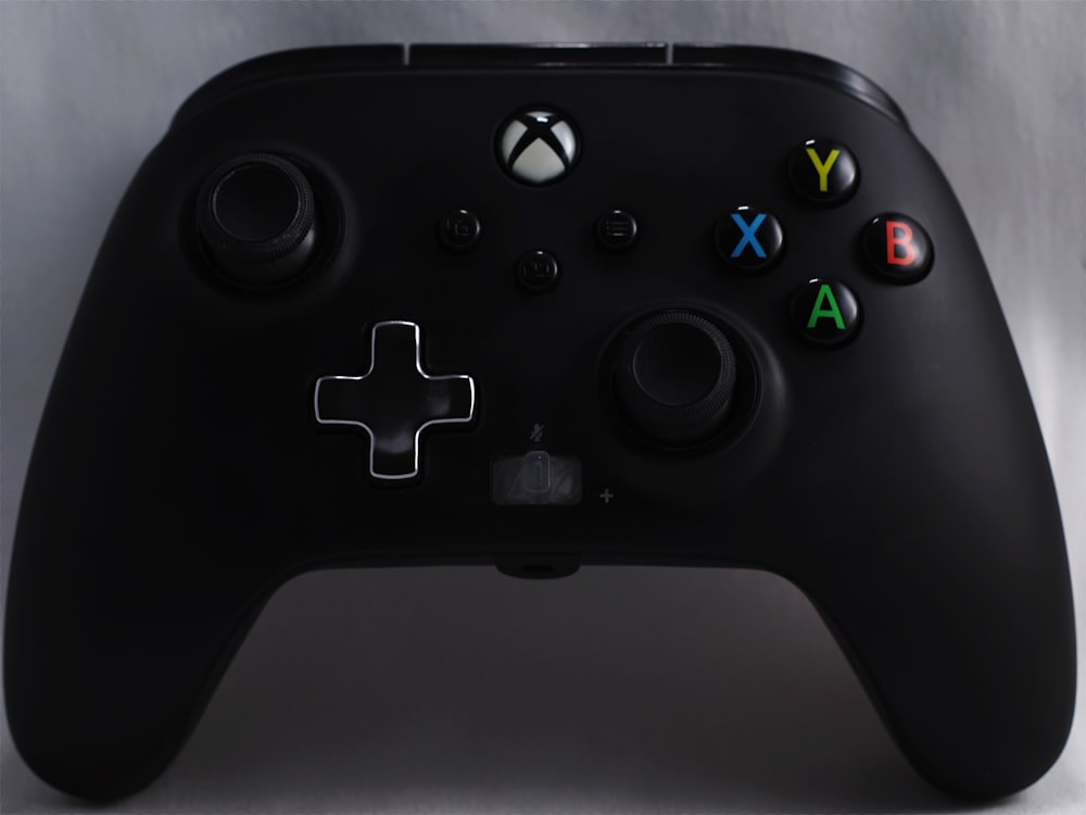 a close up of a black controller on a white background