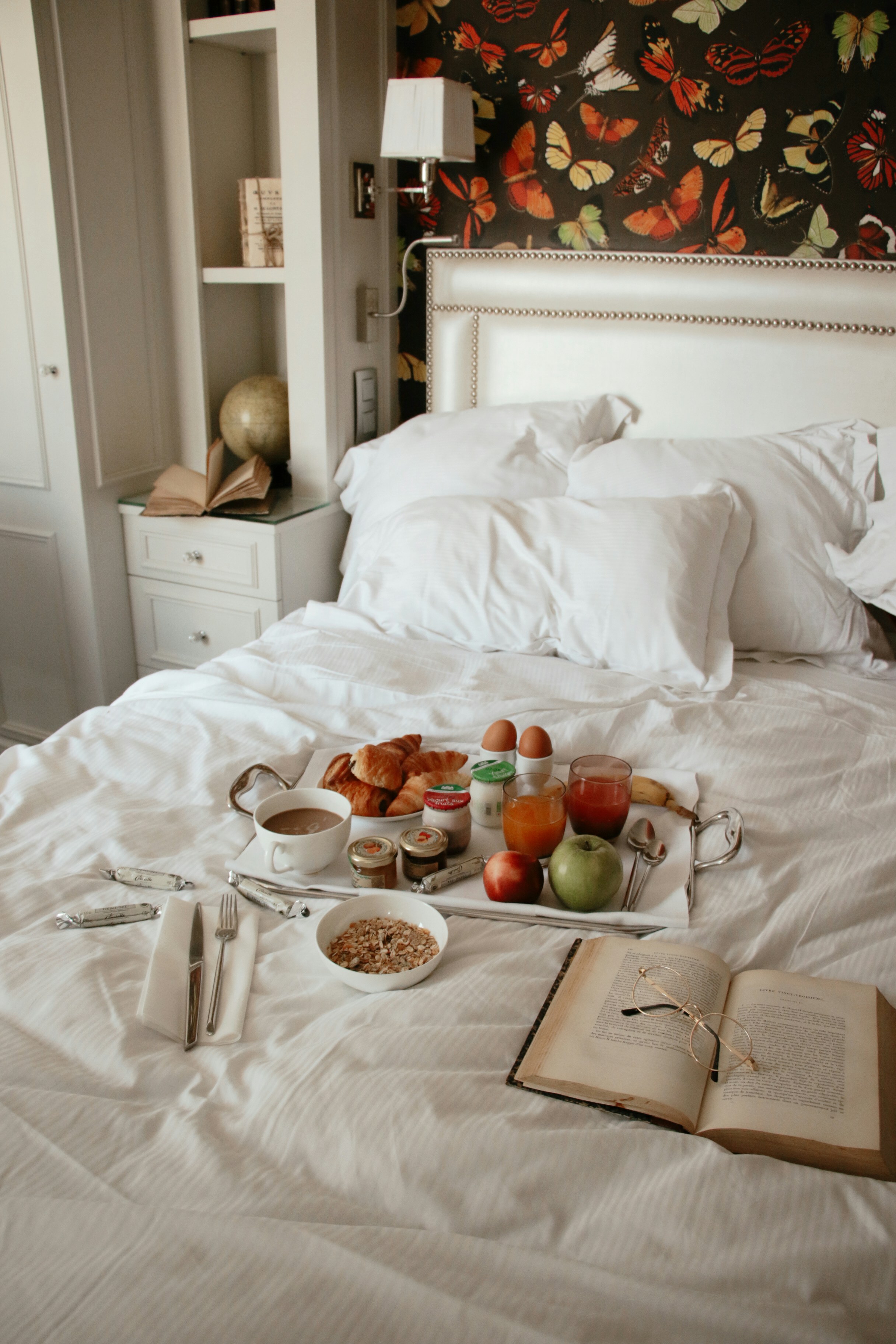 a bed with a tray of food on top of it