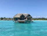 a house on stilts in the middle of the ocean