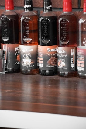 A vibrant display of various ice cream syrups in colorful bottles.