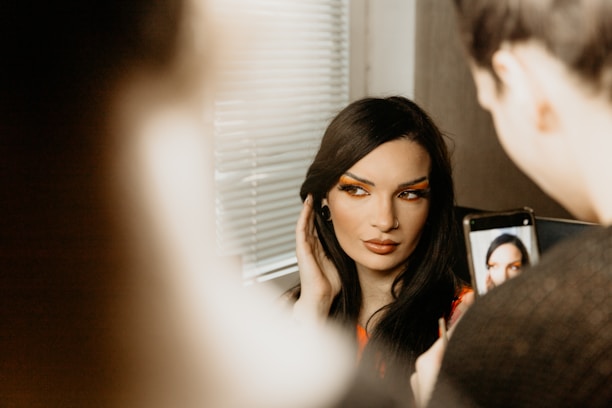 a woman is looking in a mirror with her face painted
