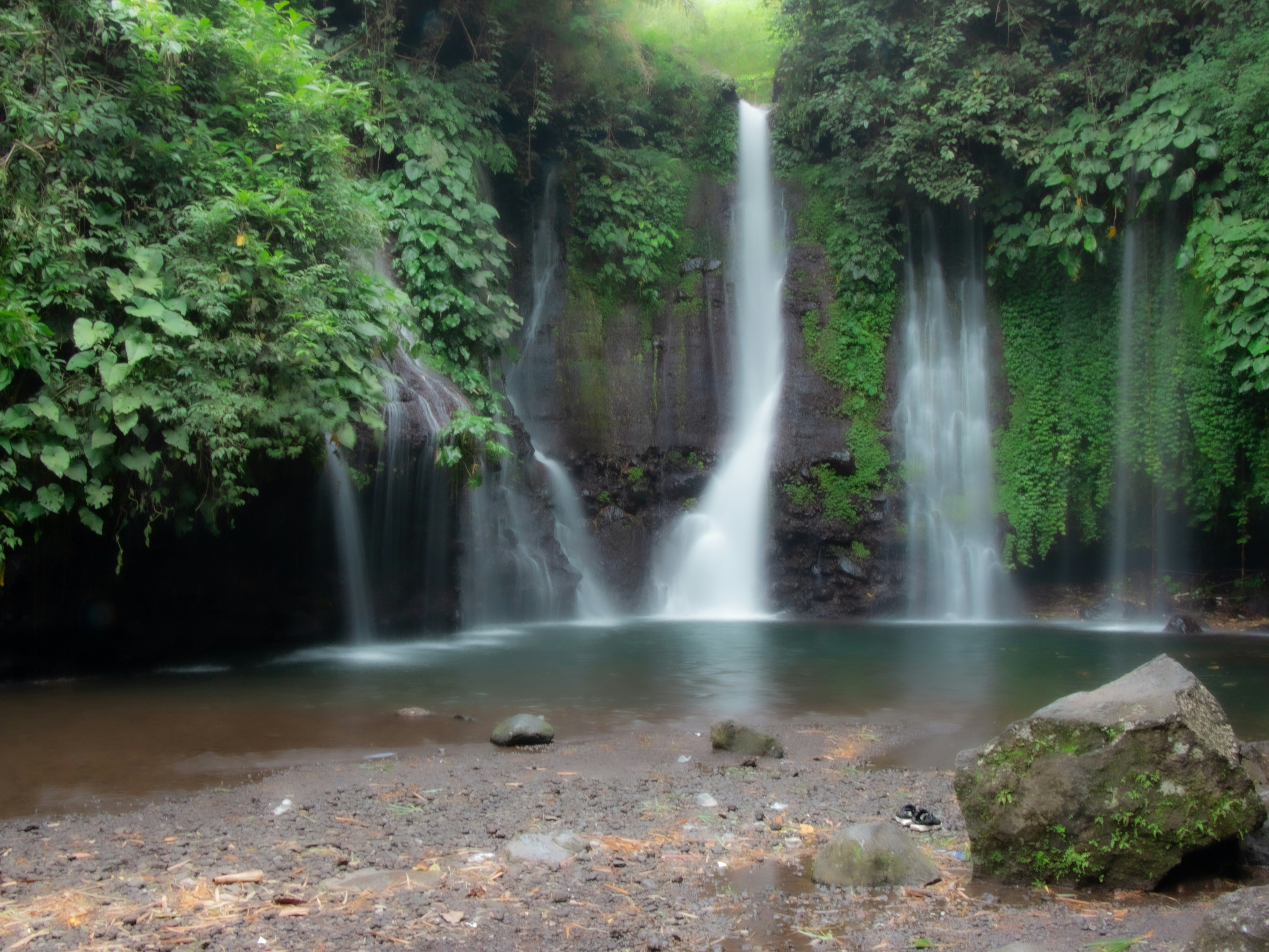 a large waterfall in the middle of a forest