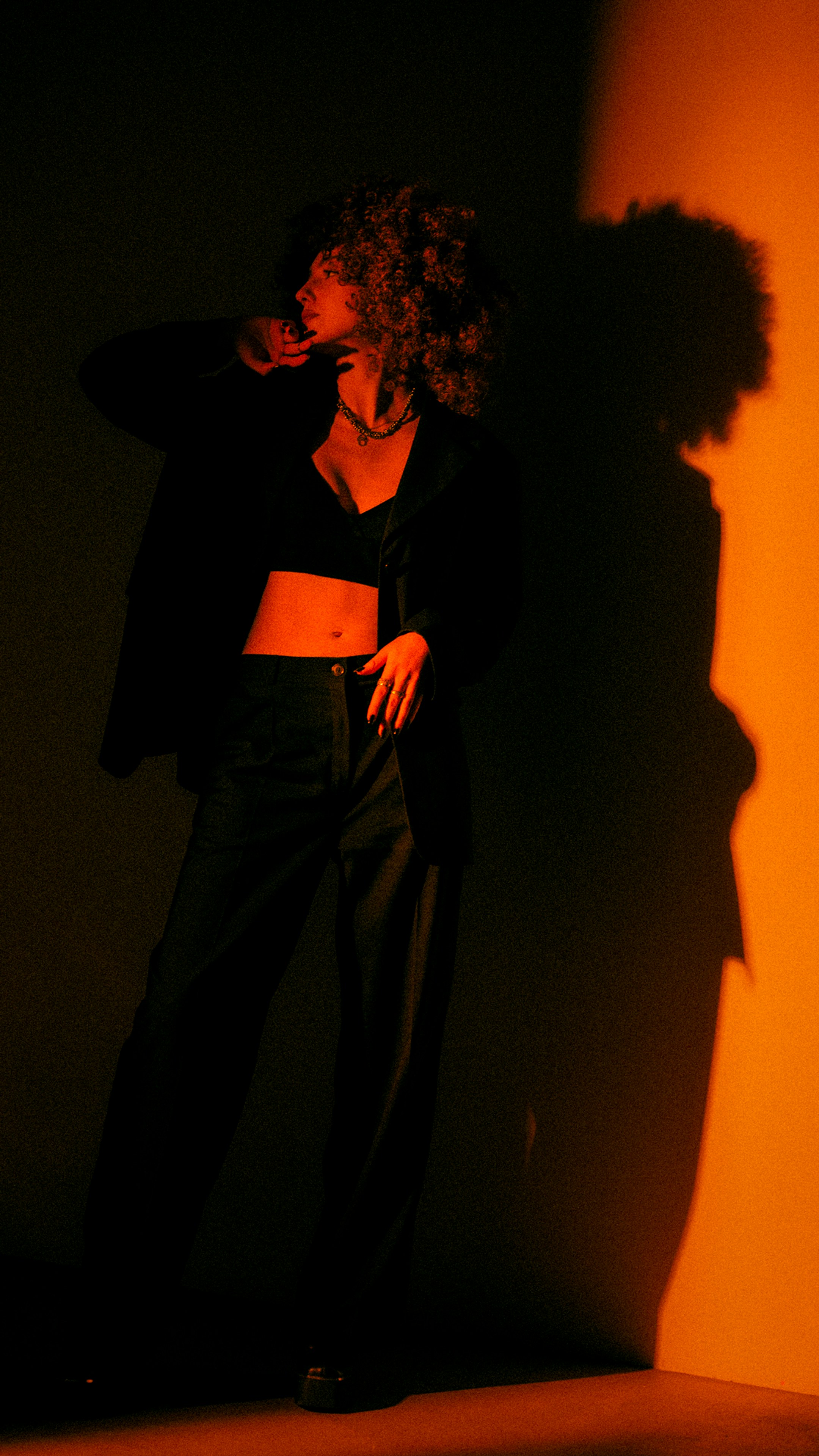 Una mujer de pie en las sombras de una pared