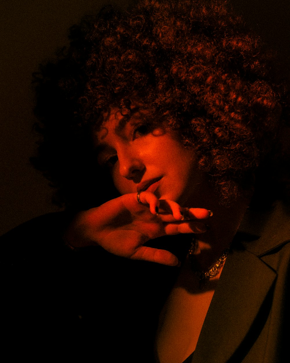 a woman with curly hair smoking a cigarette