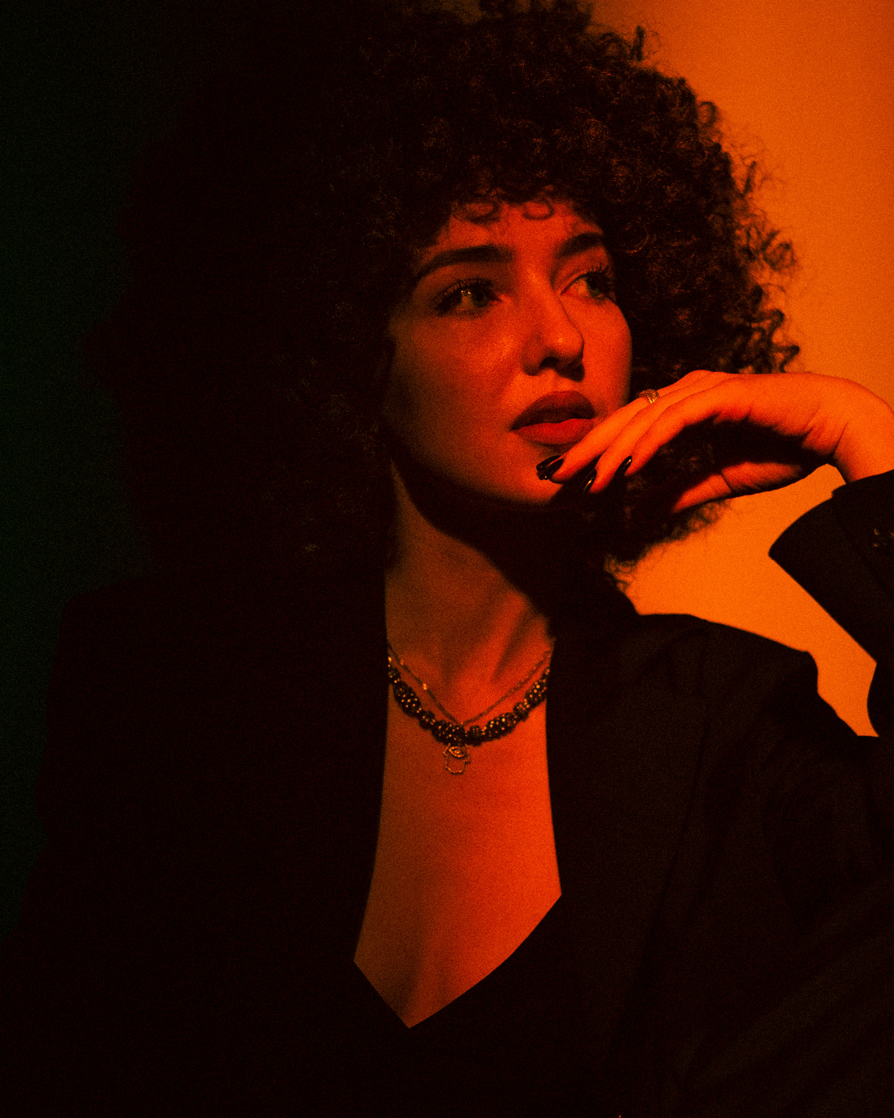 Una mujer con cabello rizado está hablando por teléfono celular