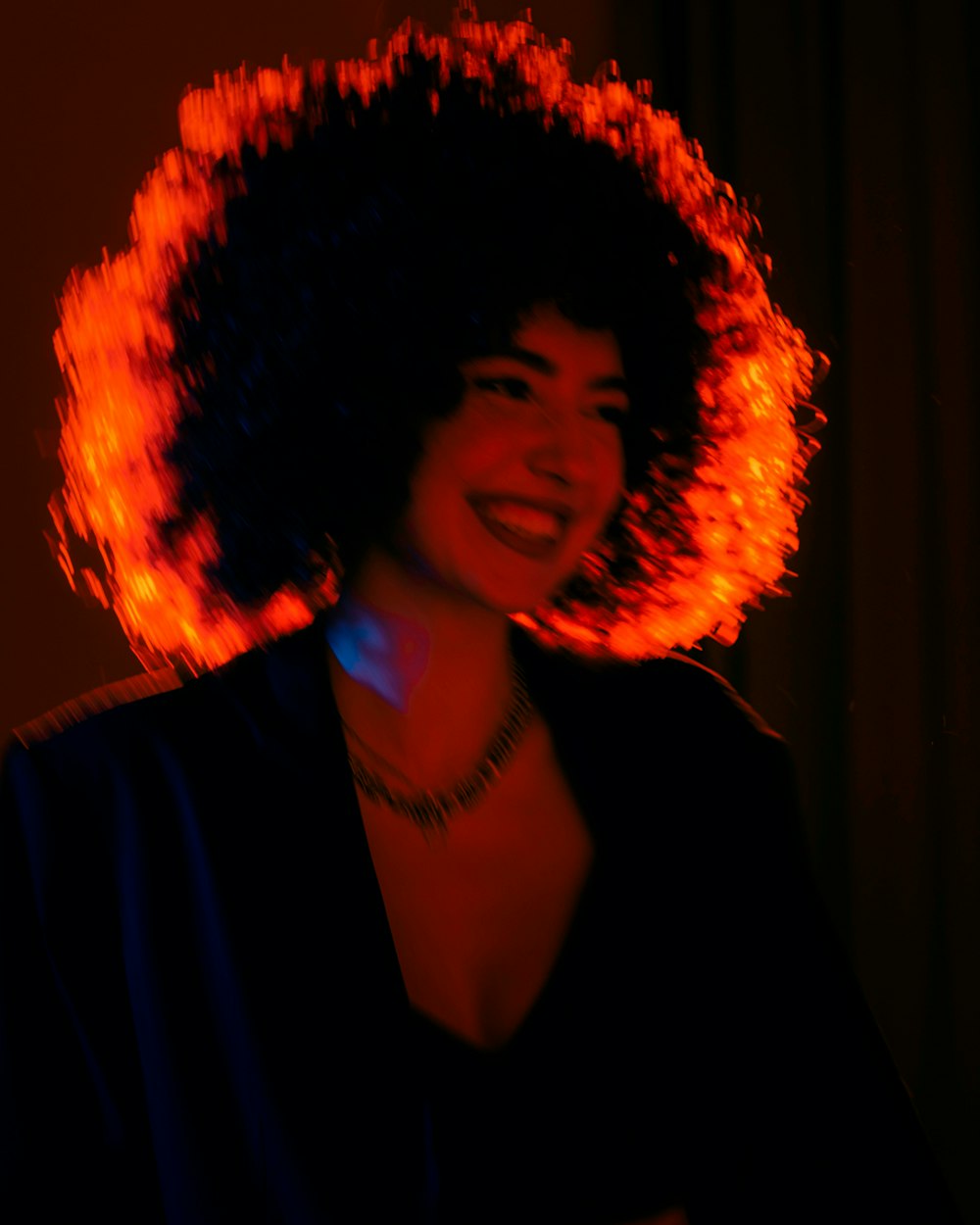 a woman with an afro is smiling at the camera