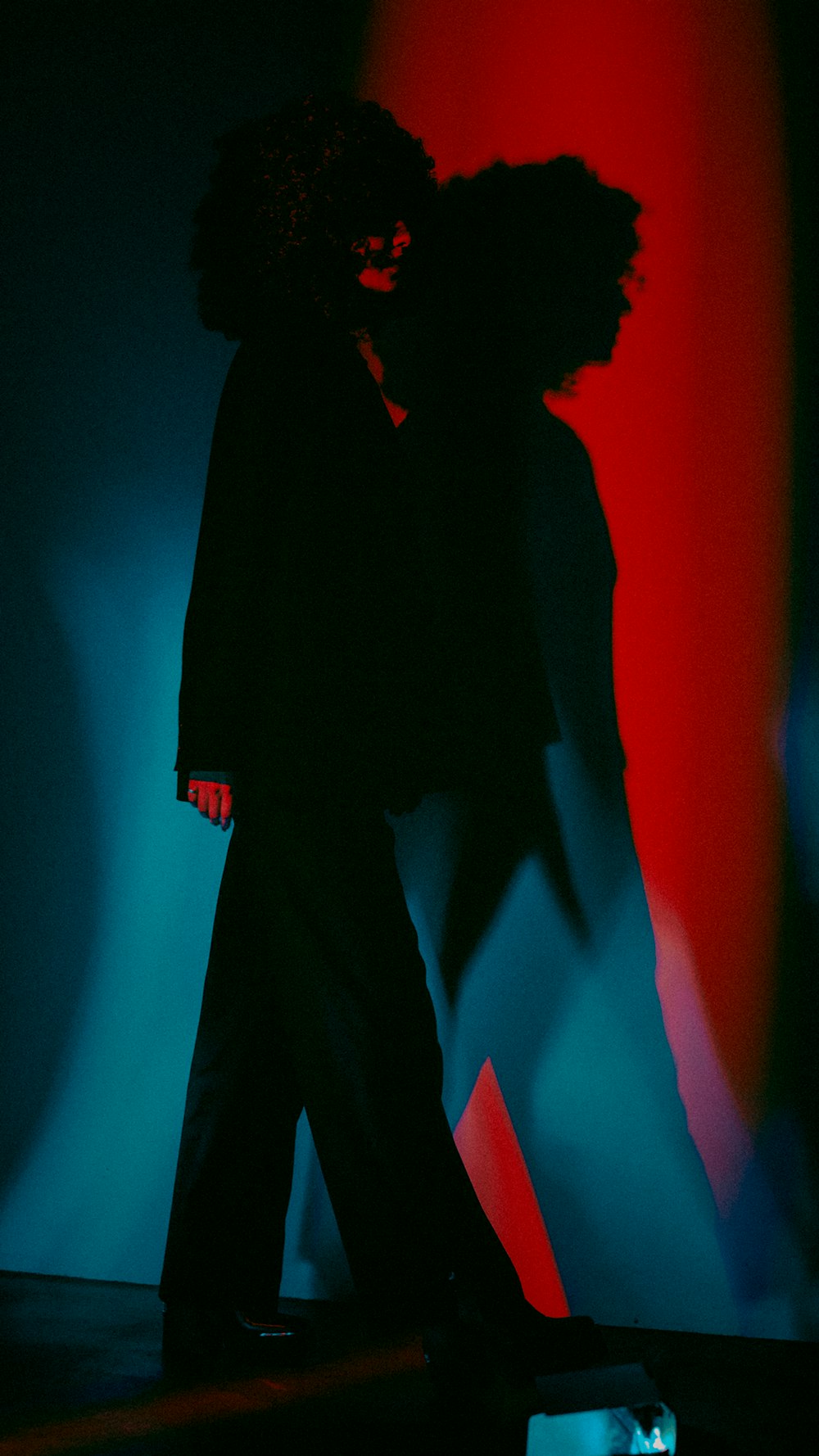 a person standing in front of a red and blue background