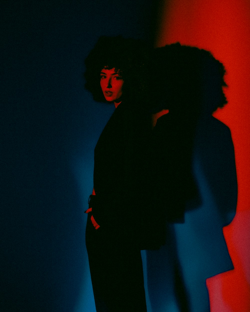 a woman standing in front of a red and blue wall