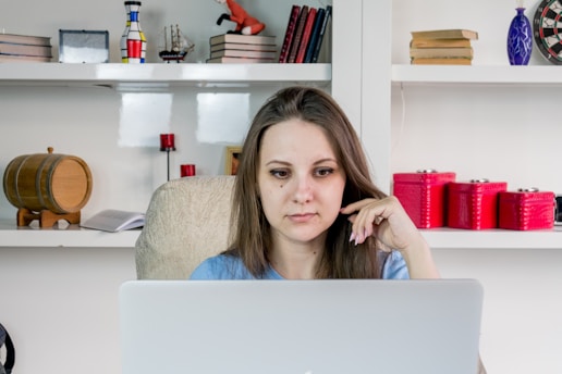 A focused businesswoman analyzing Amazon sales data on a laptop in a cozy office.