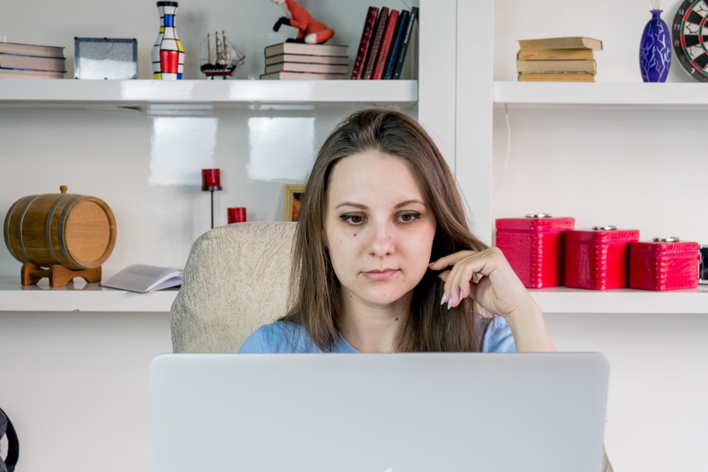 a woman sitting in front of a laptop computer