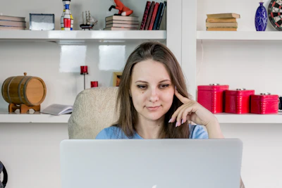 A focused professional woman studying with books and laptop in a bright, calm workspace.