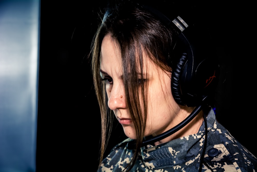 Una mujer con auriculares y mirando hacia abajo