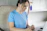 Portrait of a focused woman working on a laptop with blue neon accents in the background.