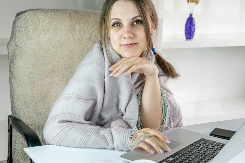 a woman sitting in front of a laptop computer