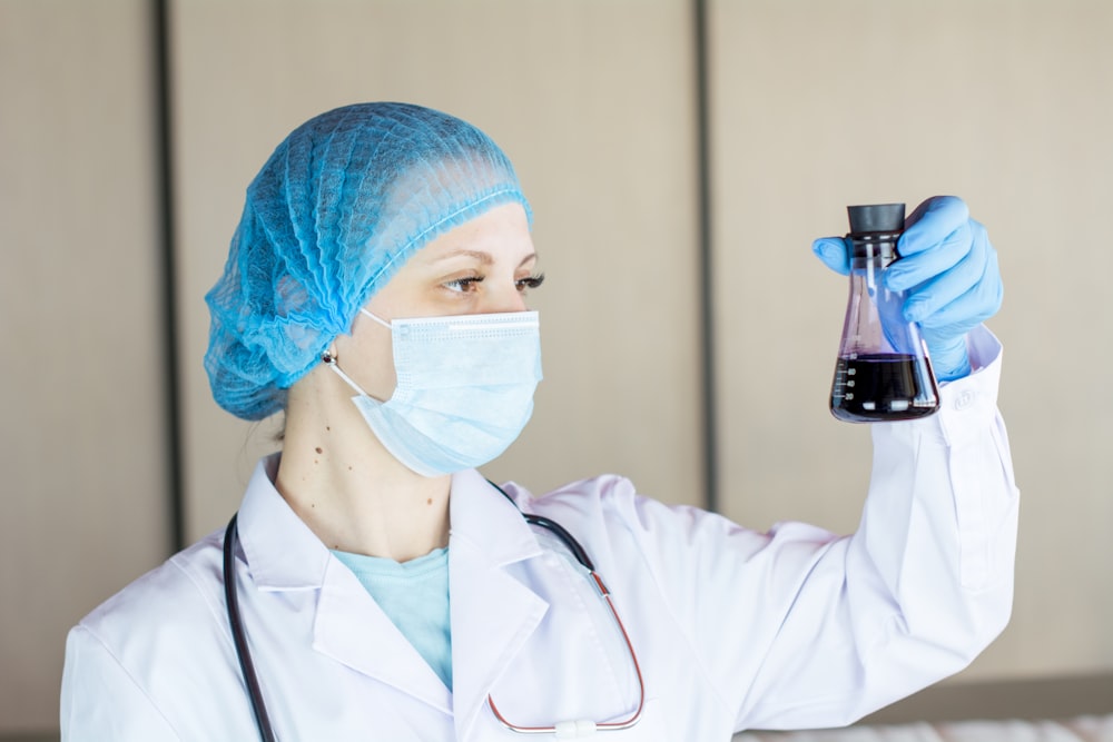 a female doctor holding a flask of liquid