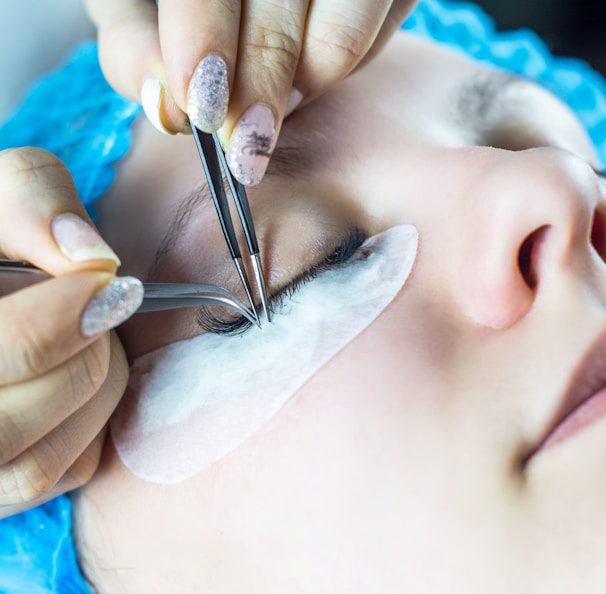 a woman getting her eyebrows done by a professional hair stylist