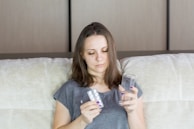A person calmly taking medication with a glass of water by their bedside.