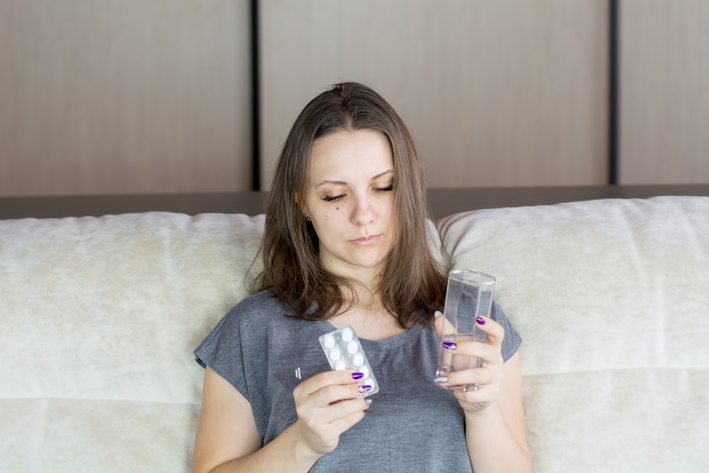 a woman sitting on a couch looking at her cell phone