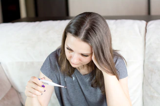 a woman sitting on a couch holding a pen and paper