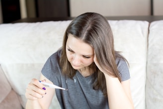 a woman sitting on a couch holding a pen and paper