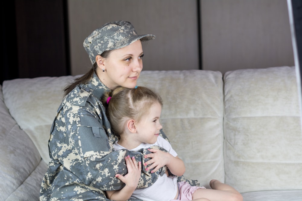 Una mujer con uniforme militar sosteniendo a un bebé