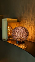 Intricate 3D printed decorative lamp glowing warmly in a cozy room