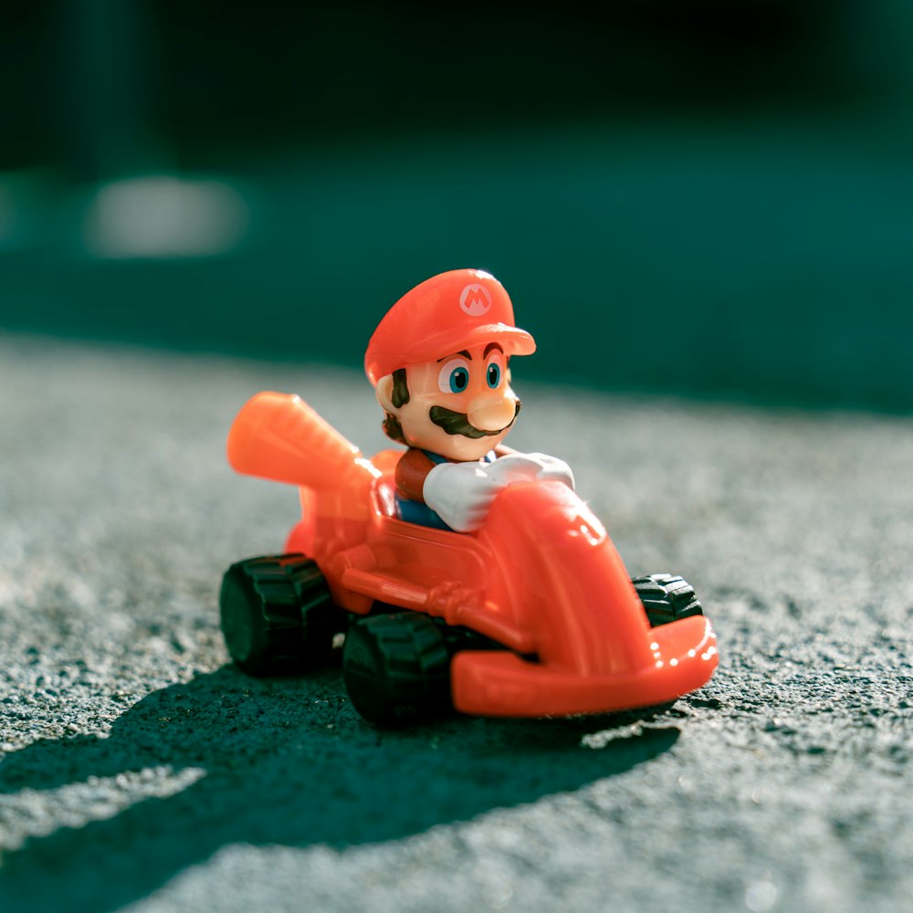 a small toy of a man riding a toy car