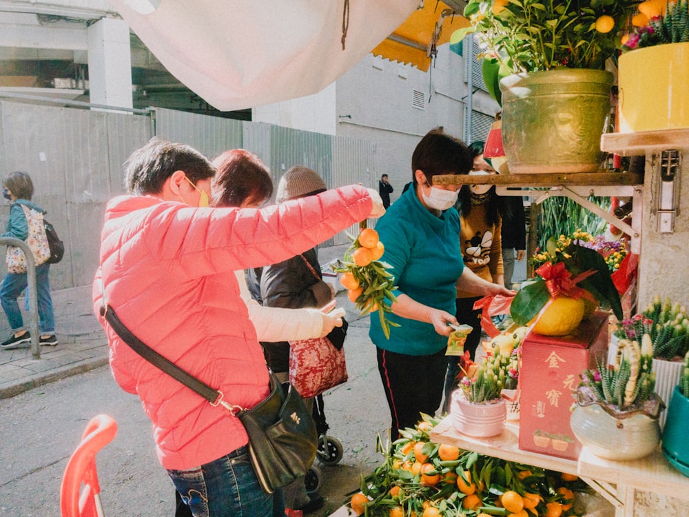 a group of people standing around a table filled with plants