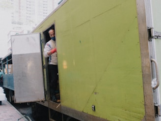 A friendly Routecore Transportation driver handing over a medical equipment package at a hospital entrance.