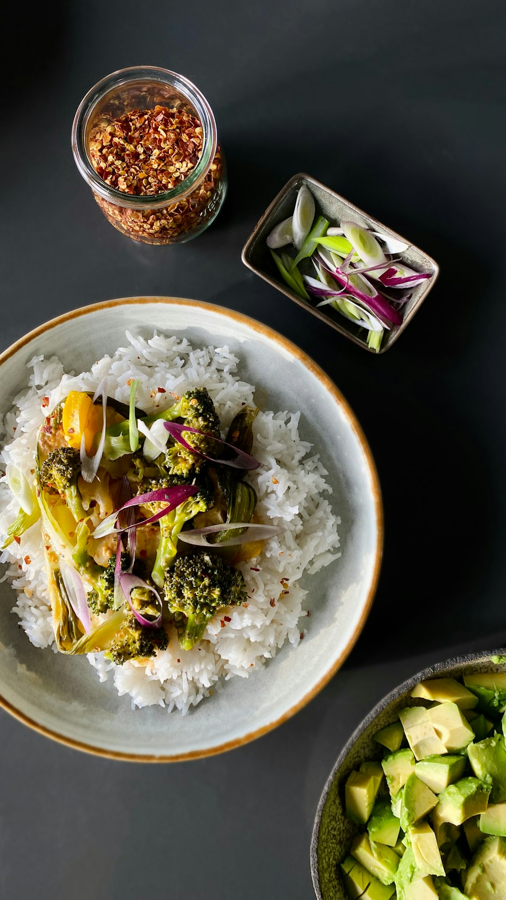 a plate of rice, broccoli, and other vegetables