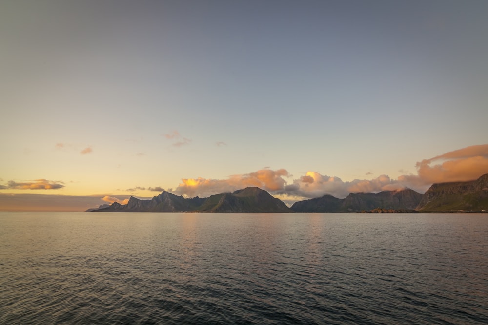 a large body of water with mountains in the background