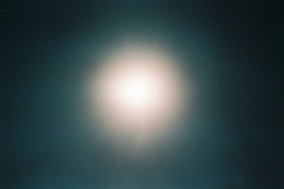 Elegant golden logo centered on a deep green gradient background with subtle light effects.