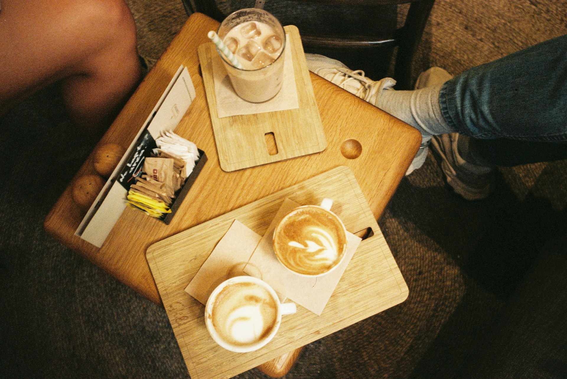 a person sitting at a table with two cups of coffee
