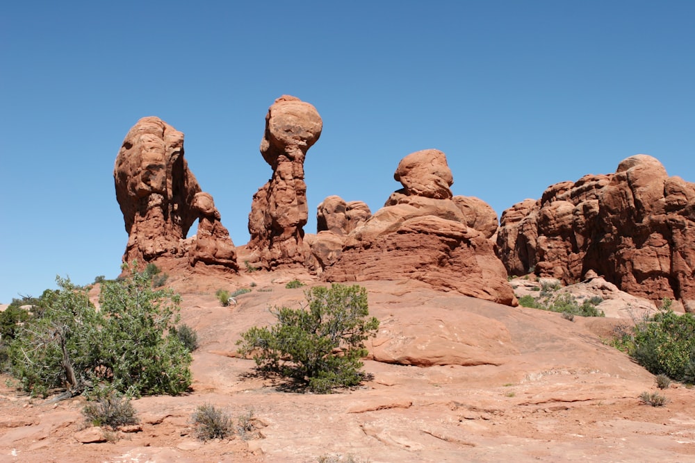 a rock formation in the desert with trees in the foreground