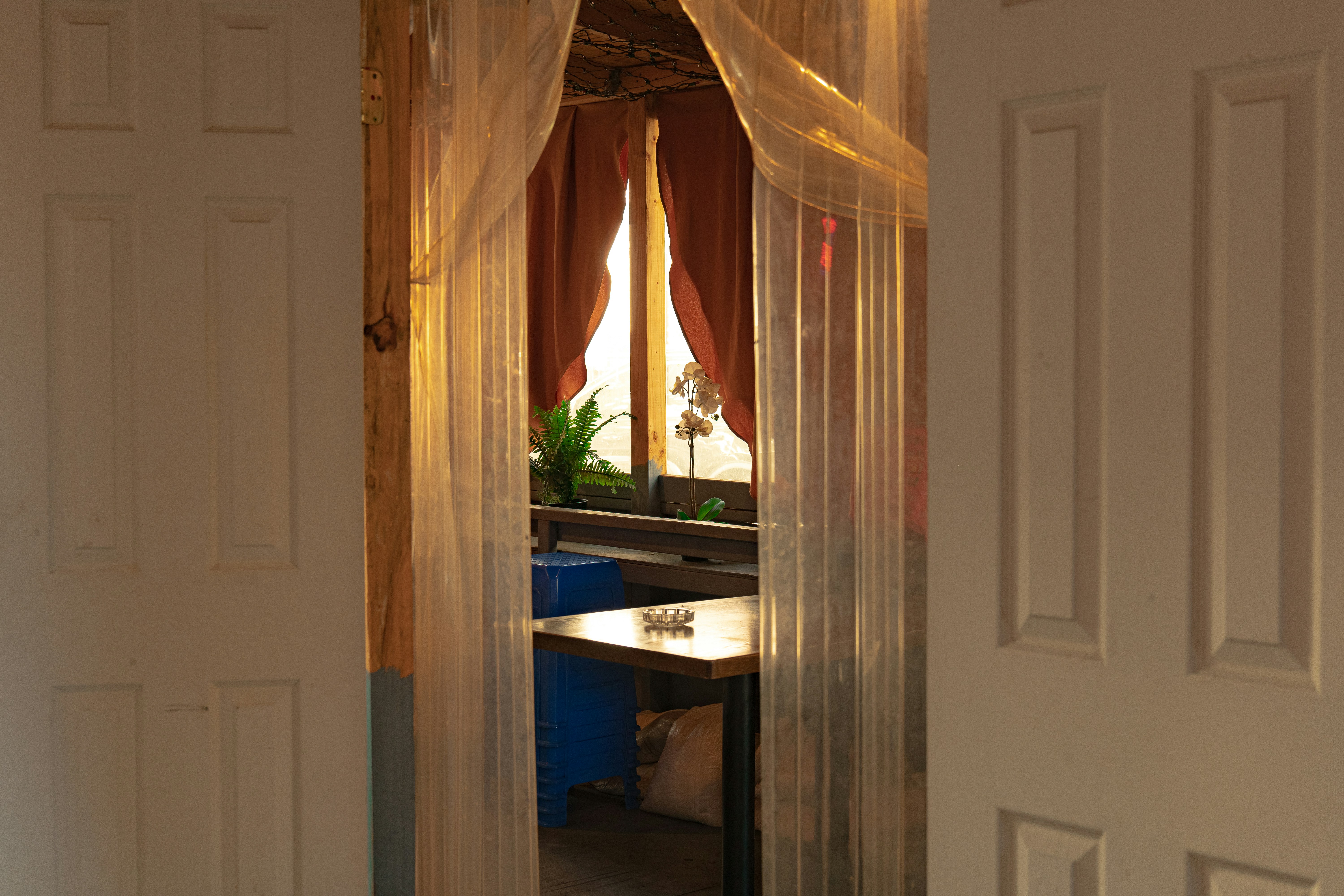 a room with a door and a window with sheer curtains