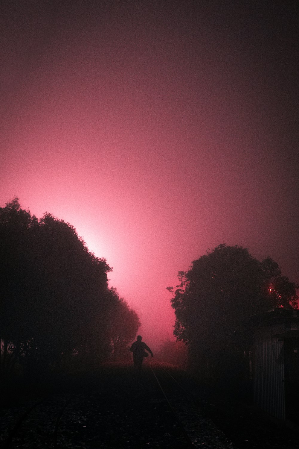 a person walking down a road in the dark