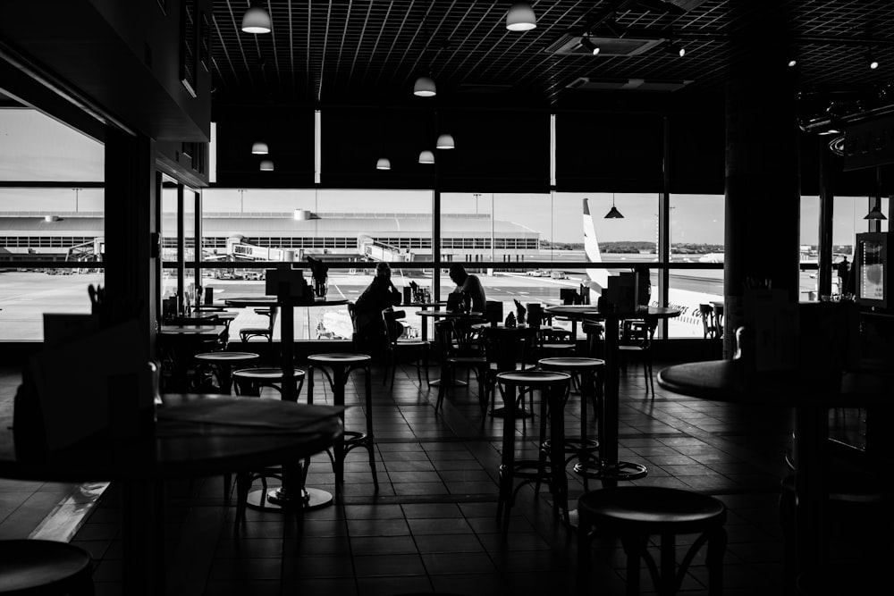 a black and white photo of people sitting at tables