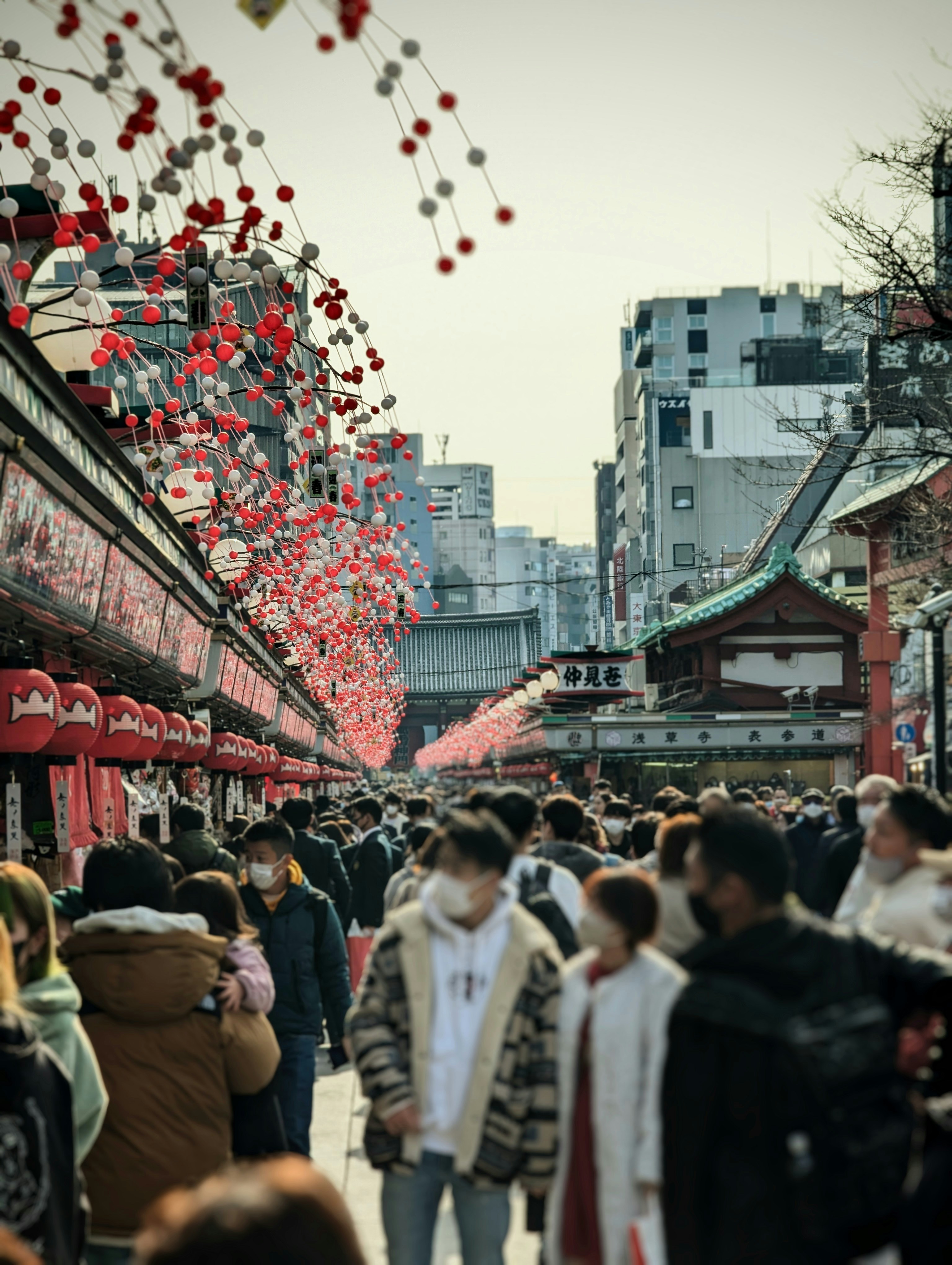 a crowd of people walking down a street next to tall buildings