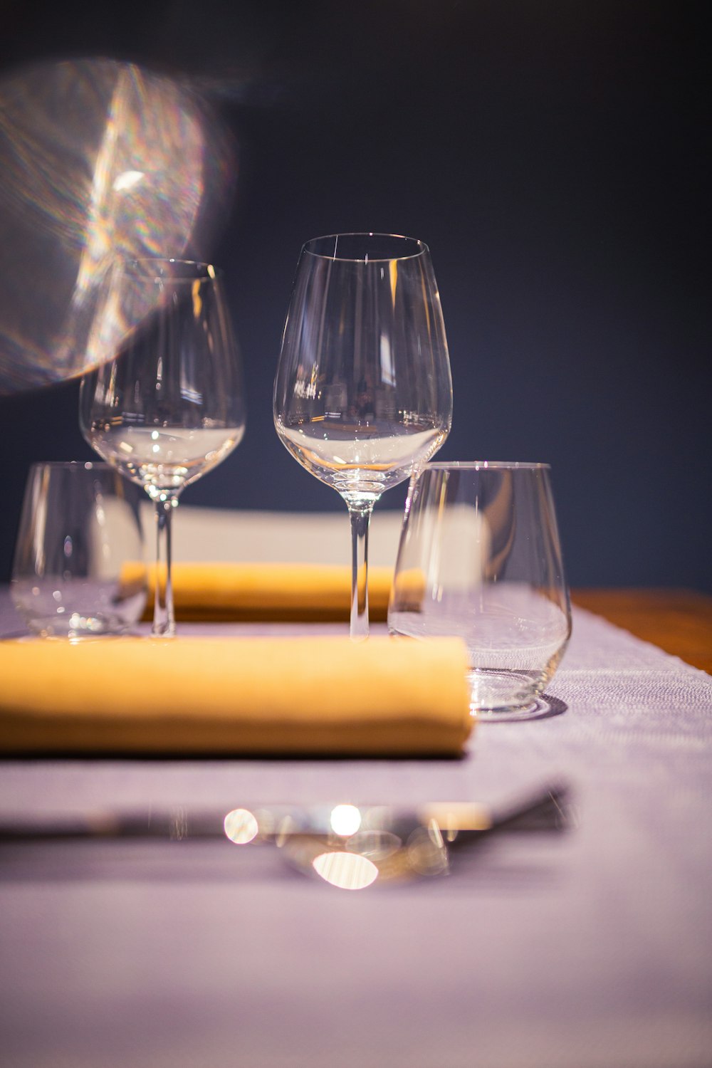 a table topped with wine glasses and a yellow napkin