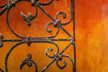 Close-up of a craftsman’s hands installing a custom gate with wrought iron details.