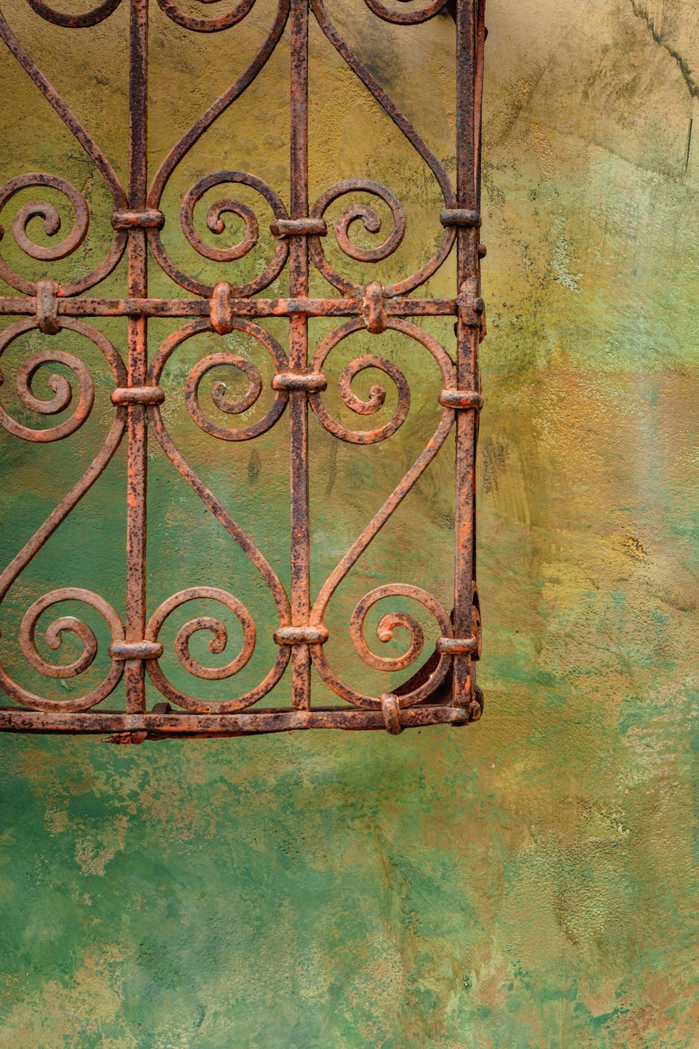 a rusted iron window on the side of a building