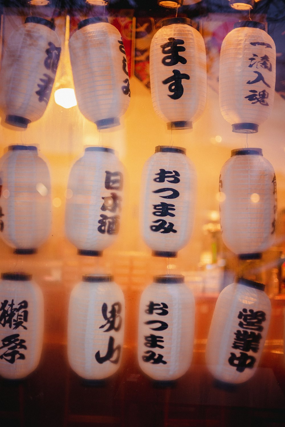 a bunch of white lanterns with asian writing on them