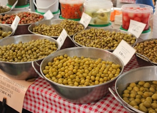 a table topped with metal bowls filled with different types of food