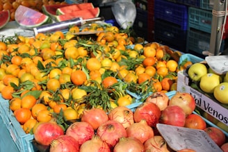 a fruit stand with oranges, apples, and watermelon